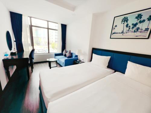 a hotel room with two beds and a couch at HiSea Nha Trang in Nha Trang
