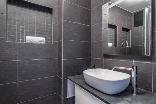 une salle de bain avec un lavabo blanc et un miroir dans l'établissement Skyflow - Sur l'île de Nantes, à Nantes