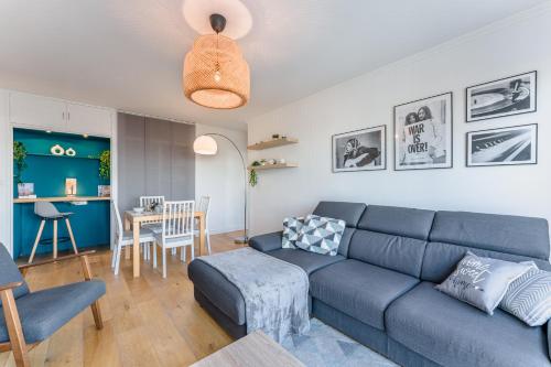 un salon avec un canapé bleu et une table dans l'établissement Skyflow - Sur l'île de Nantes, à Nantes