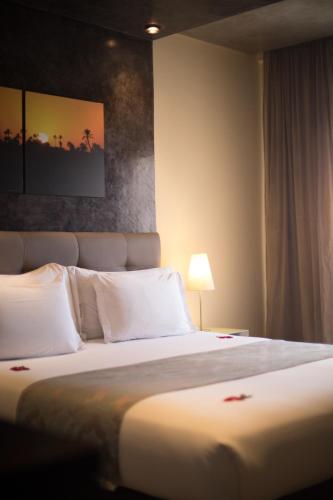 a bedroom with a large bed with white pillows at Dellarosa Boutique Hotel and Spa in Marrakech