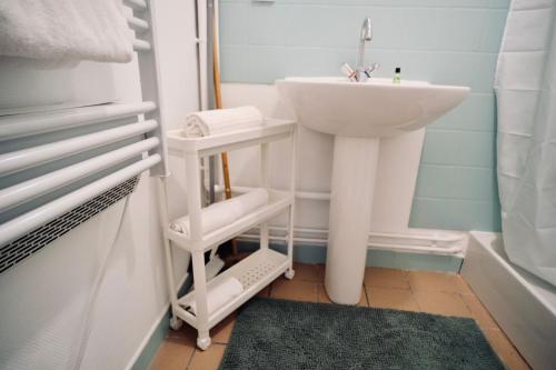 La salle de bains est pourvue d'un lavabo et d'un lavabo blanc. dans l'établissement Canal Varignon, à Caen