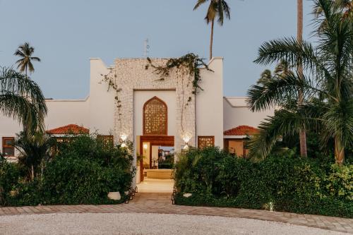 an exterior view of a building with palm trees at LUX Marijani Zanzibar in Pwani Mchangani