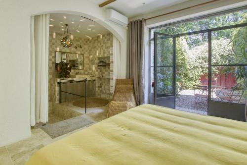 een slaapkamer met een groot bed en een groot raam bij Le Mas des Anges in Cabannes