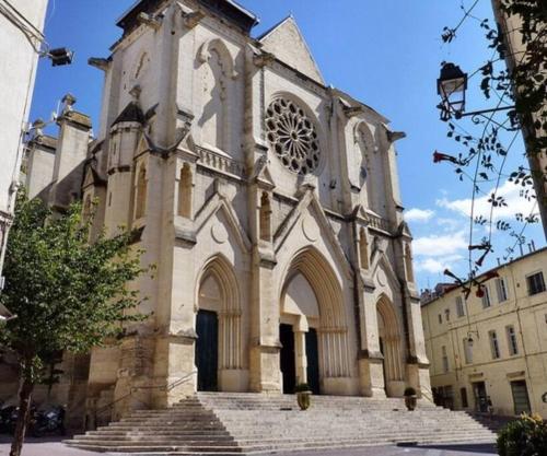 Une ancienne église avec des escaliers devant elle dans l'établissement Centre ville Montpellier - Appartement au coeur de l'écusson, à Montpellier
