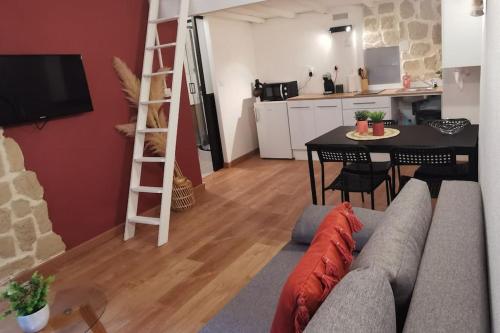 un salon avec un canapé et une table et une cuisine dans l'établissement Centre ville Montpellier - Appartement au coeur de l'écusson, à Montpellier