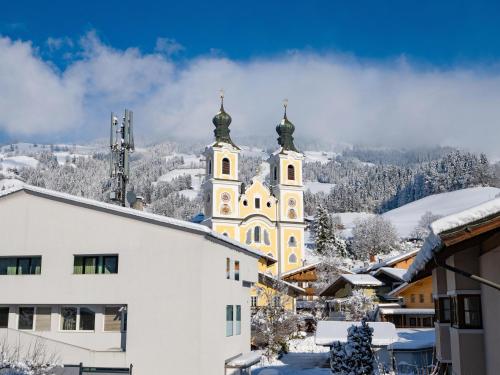 a church with two domes on top of a snow covered city at Ferienwohnungen Egger in Hopfgarten im Brixental