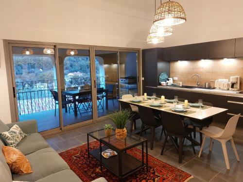 a living room with a table and a kitchen at LA MAISON BARNOIN - gîtes et chambres in Bouyon