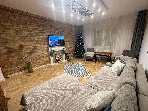 a living room with a couch and a brick wall at Season One Apartman in Szeged