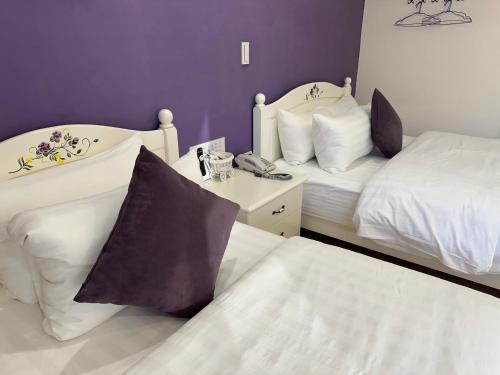 two beds in a room with purple and white at Bei Ao Bi Shan Jyu in Dongyin