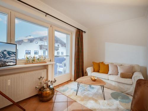 a living room with a couch and a large window at Ferienwohnungen Egger in Hopfgarten im Brixental