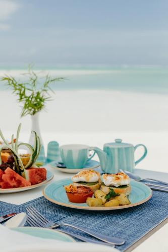 a table with plates of food on a table at LUX* Marijani Zanzibar in Pwani Mchangani