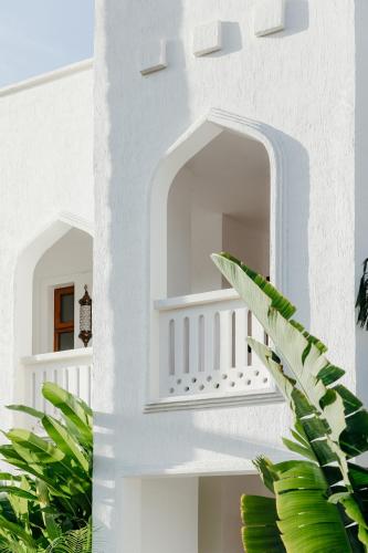 a staircase in a white house with a plant at LUX* Marijani Zanzibar in Pwani Mchangani