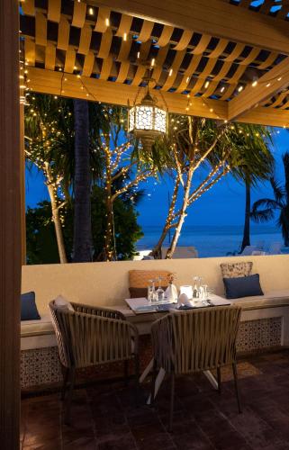 a restaurant with a table with a view of the ocean at LUX* Marijani Zanzibar in Pwani Mchangani