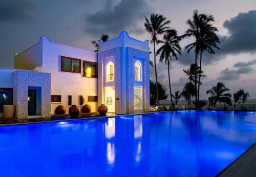 a villa with a swimming pool at night at LUX* Marijani Zanzibar in Pwani Mchangani