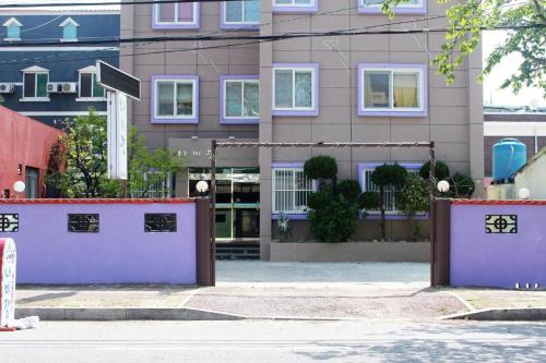 麗水的住宿－Nabizam Motel，前方有紫色墙的建筑