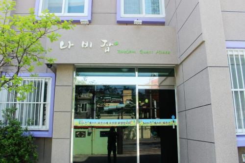 a building with a man standing outside of it at Nabizam Motel in Yeosu