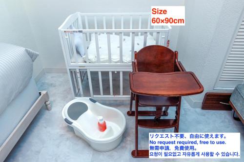 a baby crib with a chair and a baby seat at Yomitan kuba house in Yomitan