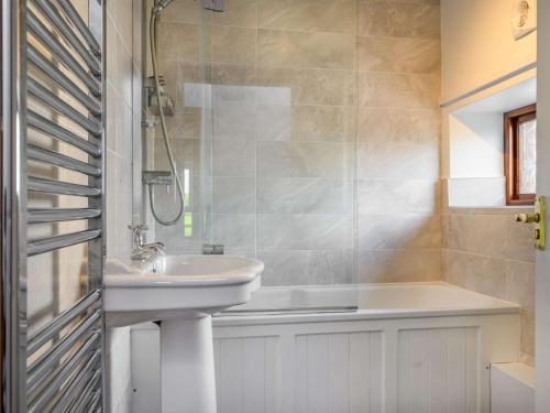 a bathroom with a sink and a bath tub at 3 bed in Caldbeck 88035 