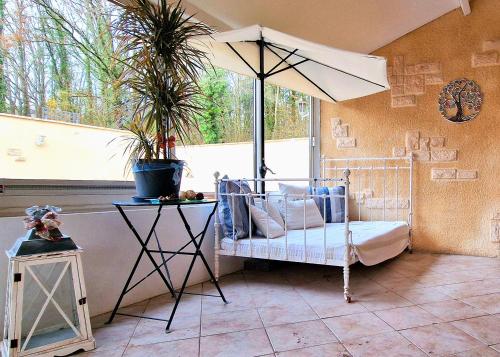 Cette chambre comprend un lit avec un parasol et une table. dans l'établissement Gîte Fontainebleau Forestier de l'abeilleur, à La Celle-sur-Seine