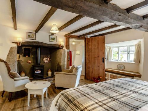1 dormitorio con 1 cama y sala de estar con chimenea en 2 Bed in Chagford 89119, en Throwleigh