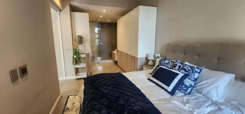 a bedroom with a bed with a blue pillow on it at Menlyn Maine Trilogy Penthouse 42 in Pretoria