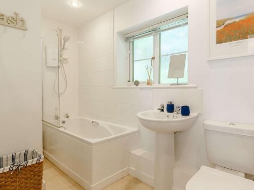 ein weißes Badezimmer mit einem Waschbecken, einer Badewanne und einem WC in der Unterkunft 1 Bed in Tintagel 89239 in Davidstow