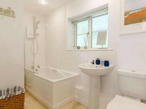 a white bathroom with a sink and a tub and a toilet at 1 Bed in Tintagel 89239 in Davidstow