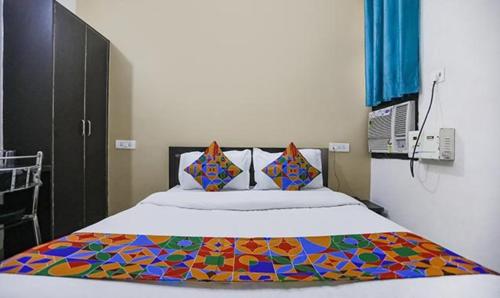 KakarmathaにあるFabHotel Lily Grandのベッドルーム1室(カラフルな毛布付きのベッド1台付)