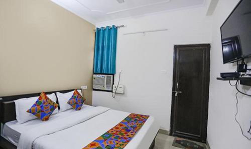 FabHotel Lily Grand في Kakarmatha: غرفة نوم بسرير وستارة زرقاء