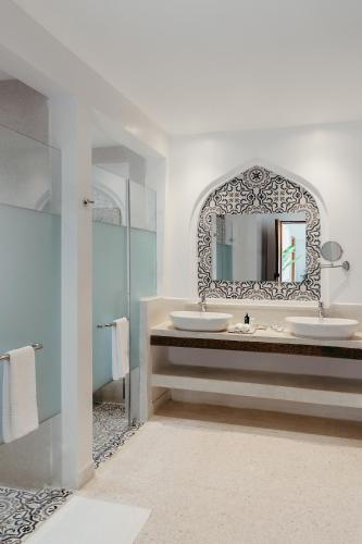 a bathroom with two sinks and a mirror at LUX* Marijani Zanzibar in Pwani Mchangani