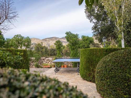 a blue table in a garden with bushes at Can Colet by Sunvillas Mallorca in Pollença