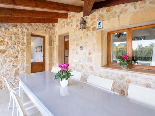 a dining room with a table and white chairs at Can Colet by Sunvillas Mallorca in Pollença