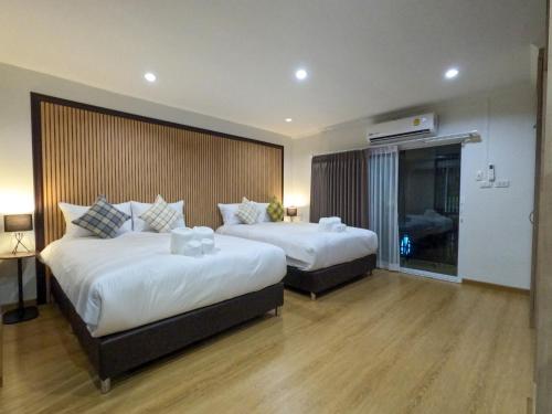 a hotel room with two beds and a window at BG Bed Hometel Hat-Yai Songkhla in Hat Yai