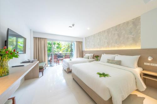 Habitación de hotel con 2 camas y escritorio en Peace Laguna Resort & Spa - SHA Extra Plus, en Ao Nang Beach