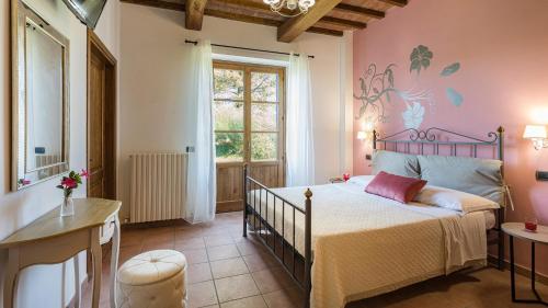 een slaapkamer met een bed met een roze muur bij TENUTA MONTIEPOLI 12&3, Emma Villas in Valfabbrica