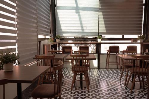 a restaurant with wooden tables and chairs and windows at The Cosy Inn Hanoi in Hanoi