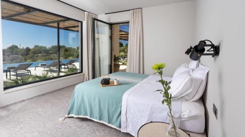 Un dormitorio con una cama y un balcón con vistas. en VILLA AMORE 8, Emma Villas, en Casa Modica