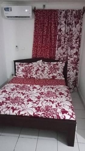 1 cama roja y blanca en una habitación en Résidences Lili, en Douala