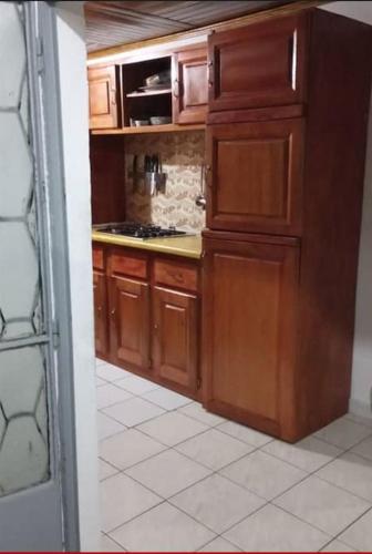 - une cuisine avec des placards en bois dans l'établissement Résidences Lili, à Douala