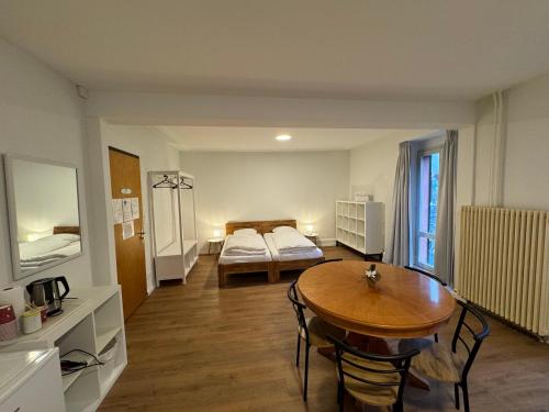 a room with a table and a bed and a bedroom at Downtown Family&Friends in Interlaken