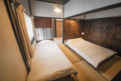 een kleine kamer met een bed en een raam bij HISORI Arts and Stay in Kanazawa