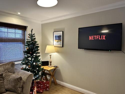 un salon avec un arbre de Noël et une télévision dans l'établissement Yew Tree Court, à Heswall