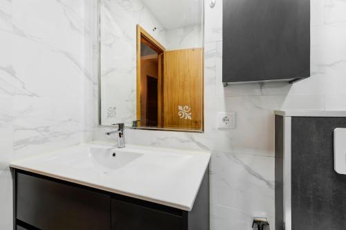 een badkamer met een wastafel en een spiegel bij Teixeira Expo in Lissabon