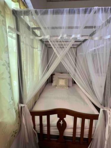 a small bed in a room with mosquito nets at Wattala Villa- The Guardian Bungalow in Wattala