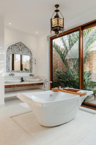 a white bathroom with two sinks and a tub at LUX* Marijani Zanzibar in Pwani Mchangani