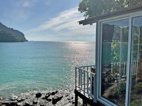 a view of the water from a house with a window at The Cobble Beach Hotel- Phi Phi Island in Phi Phi Don