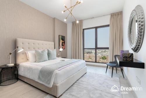 een slaapkamer met een groot wit bed en een bureau bij Dream Inn Apartments - Rahaal - Burj al Arab View in Dubai