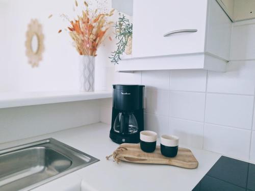 a kitchen counter with a coffee maker and two cups at Shorebreak Nieuwpoort near the beach in Nieuwpoort-Bad
