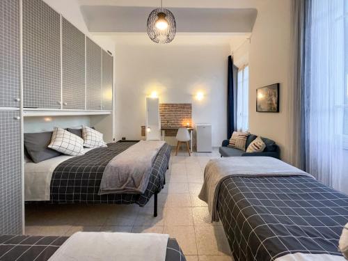 a bedroom with two beds and a couch at La Casa di Eli Appartamenti in Pisa