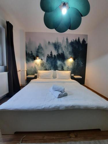 a bedroom with a large bed with a blue blanket at Askade Residence Self Check-in in Bucharest